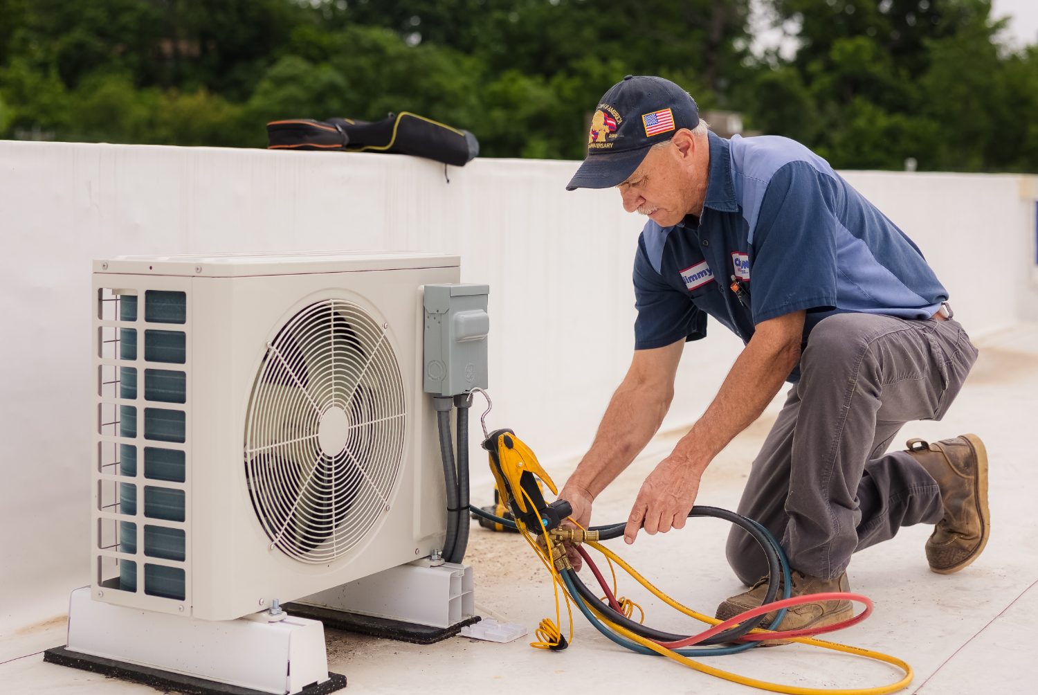 Callison technician charging a ductless mini-split air conditioning system on a rooftop in Staunton, Virginia